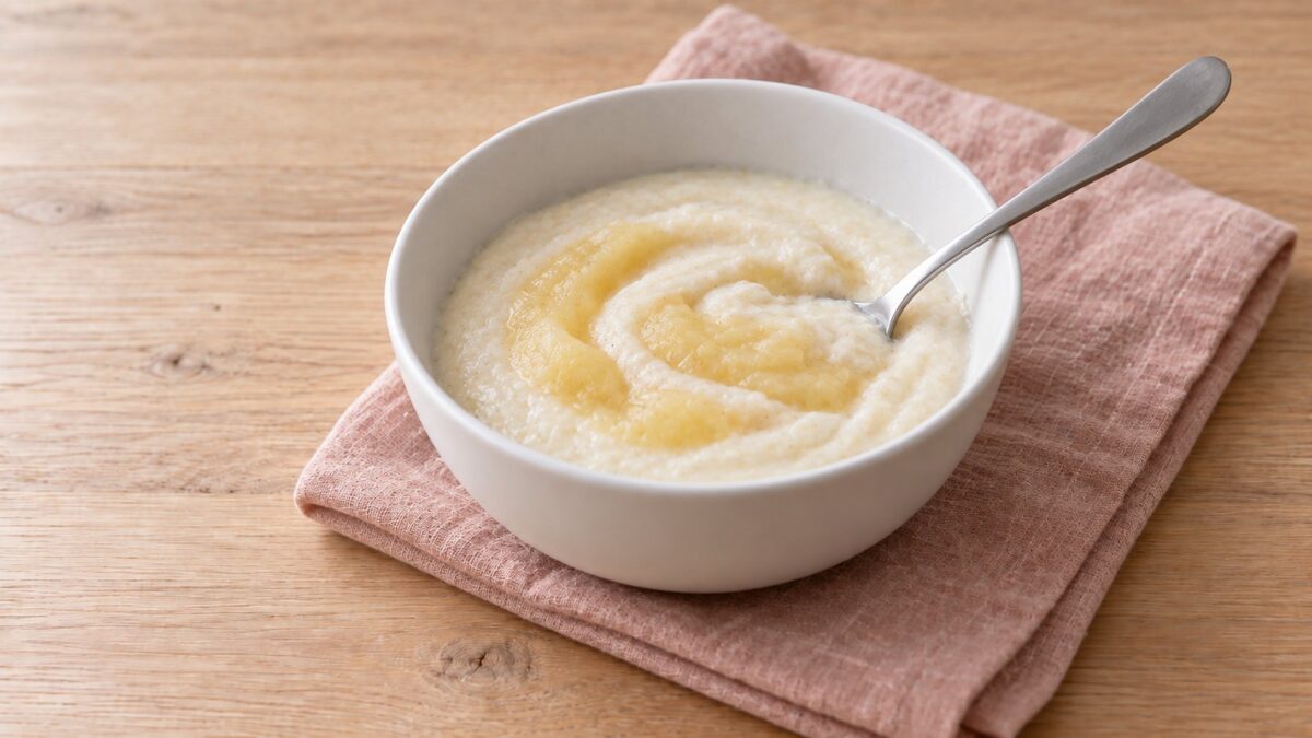 KI-generiertes Symbolbild: Milchbrei mit etwas Apfelmus in einer hohen weißen Schüssel